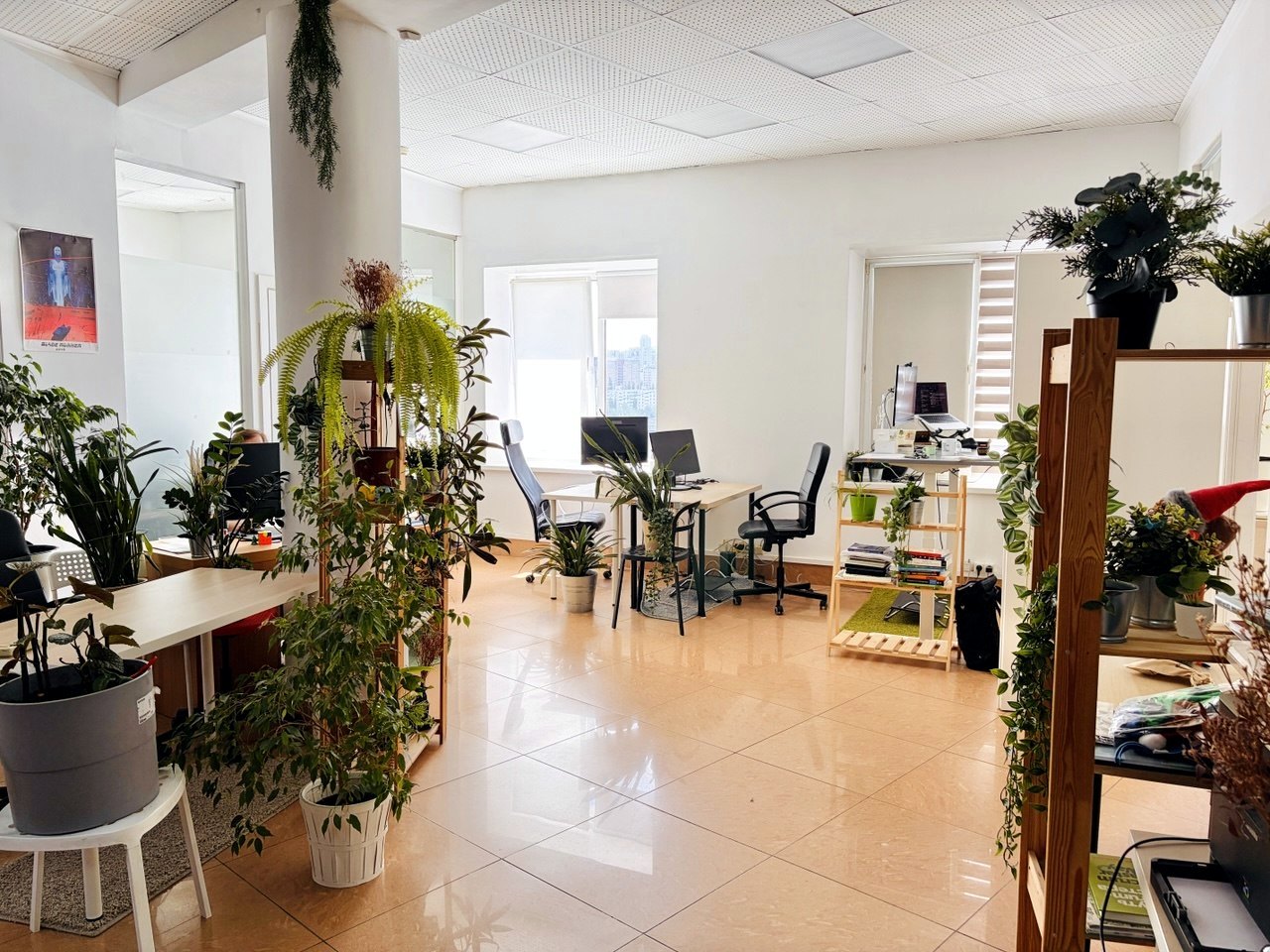 Общий зал UFA IT Coworking с рабочими местами и растениями